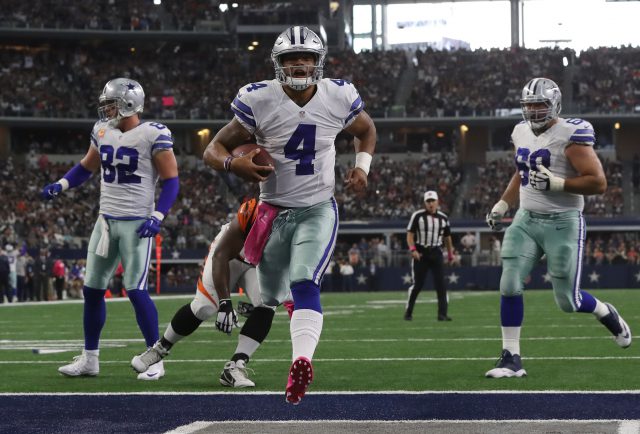 Dak Prescott #4 of the Dallas Cowboys carries the ball into the end zone for a touchdown during the first half against the Cincinnati Bengals