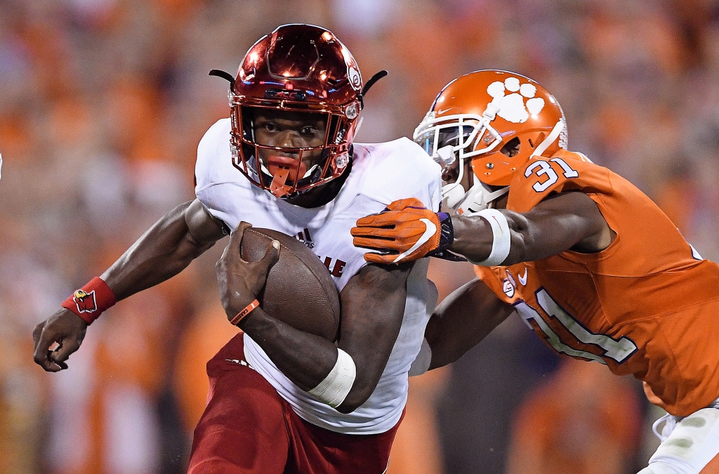 CLEMSON SC- OCTOBER 01 Lamar Jackson #8 of the Louisville Cardinals looks to avoid the tackle of Ryan Carter #31 of the Clemson Tigers during the fourth quarter at Memorial Stadium