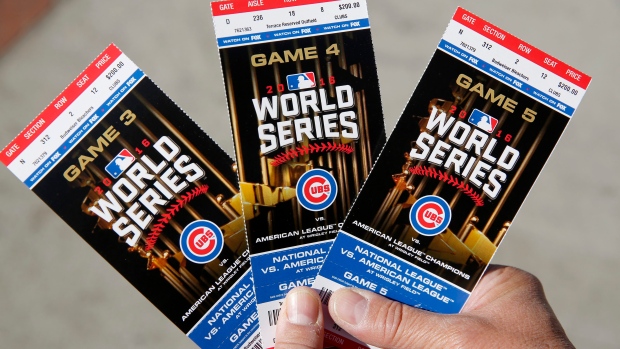 Cubs fan Robert Lyons who lives in Los Angeles but was raised in Berwyn Ill. shows his World Series tickets outside Wrigley Field Monday in Chicago