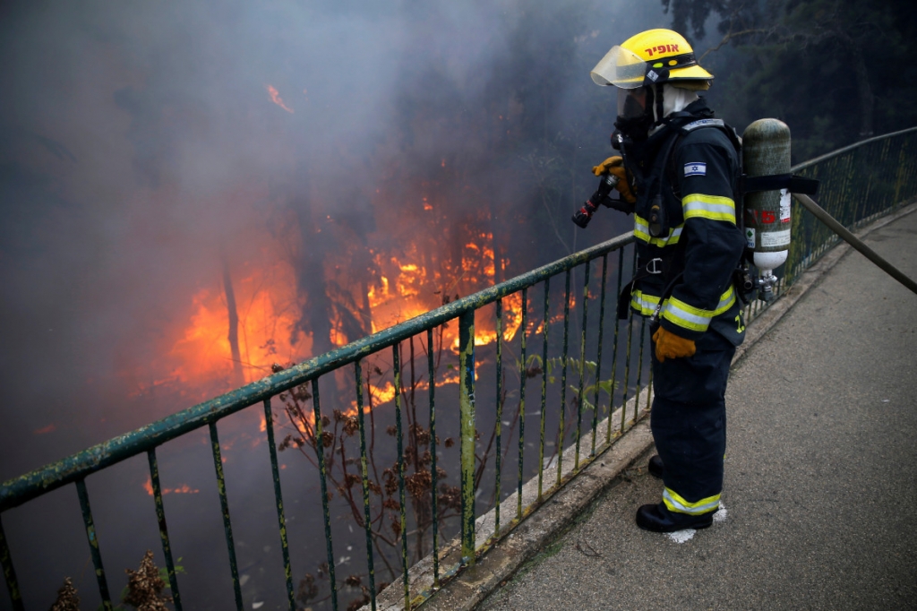 A firefighter extinguishes a wildfire in the northern city of Haifa — REUTERS