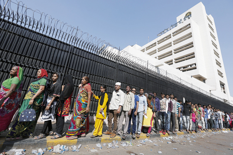 AHMADABAD Indians stand in a queue to deposit and exchange discontinued currency notes outside the Reserve Bank of India in Ahmadabad yesterday. —AP