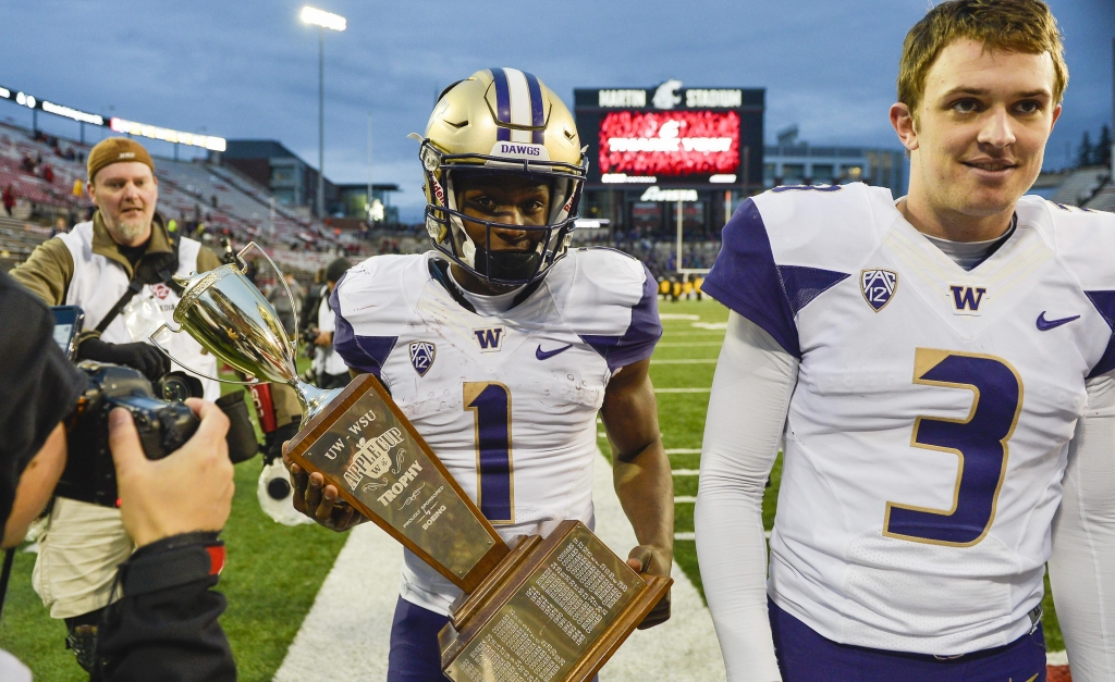 Washington quarterback Jake Browning right walks with the Apple Cup trophy as wide receiver John Ross left walks it off the field after Washington beat Washington State 45-17 Friday Nov. 25 2016 in Pullman Wash