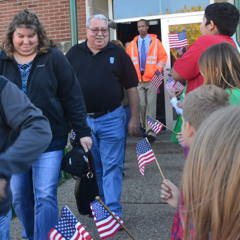 PEYTON NEELY The Marietta Times Veterans walk through a tunnel of Harmar Elementary School students waving the American flag following an assembly on Thursday