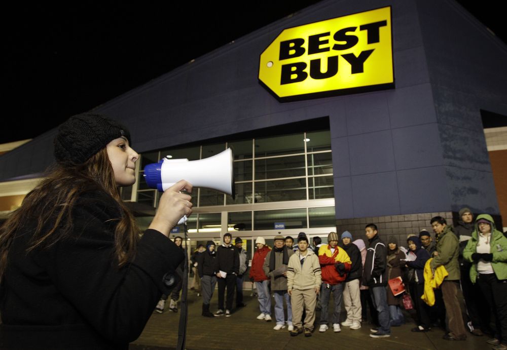 Lucia Valenuela uses a bullhorn to give instructions to crowds of shoppers lined up in the early hours of the