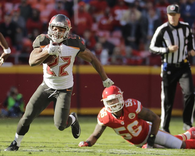 Tampa Bay Buccaneers running back Doug Martin runs past a tackle attempt by Kansas City Chiefs linebacker Derrick Johnson during the second half of an NFL football game in Kansas City Mo. Sunday Nov. 20 2016