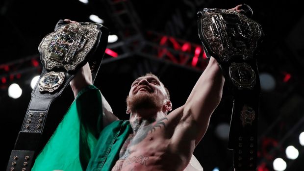 Double champ Conor Mc Gregor holds up his title belts