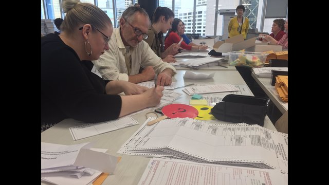 Hennepin Co. election workers are paired into 2-person teams to cross verify each absentee envelope and ballot before they are counted