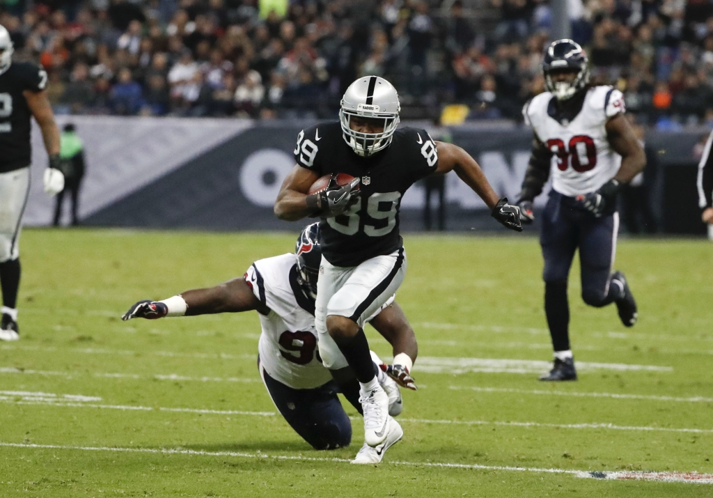 Oakland Raiders wide receiver Amari Cooper breaks away from Houston Texans defensive end D.J. Reader on his way to scoring a touchdown during the second half of an NFL football game Monday Nov. 21 2016 in Mexico City