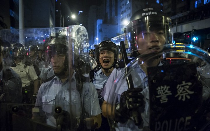 A police officer yells instructions during a protest against an expected interpretation of the city's constitution the Basic Law by China's NPCSC