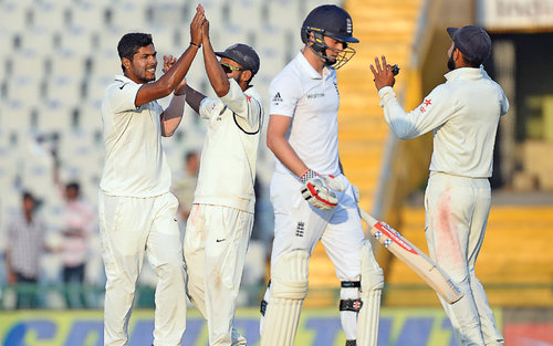 Indian bowler Umesh Yadav celebrates with his teammates after he dismissed England's Chris Woakes during the first day on Saturday