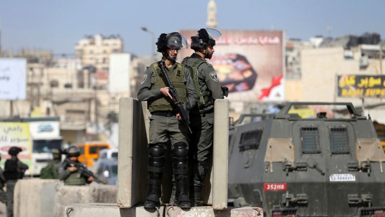 Israeli border policemen stand guard near the scene where Israeli police said a Palestinian was shot and killed by an Israeli security guard after the Palestinian tried to stab him at Qalandiya checkpoint near the West Bank city of Ramallah November 22