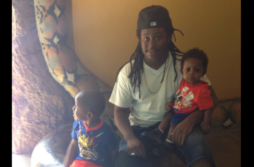 Black man sits with two young boys