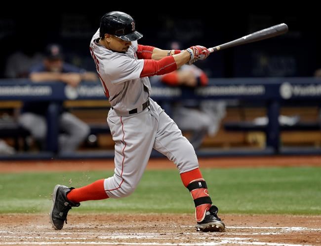 Boston Red Sox's Mookie Betts hits an RBI sacrifice fly off Tampa Bay Rays starting pitcher Jake Odorizzi during the sixth inning of a baseball game in St. Petersburg Fla. Betts Mike Trout and Jose Altuve