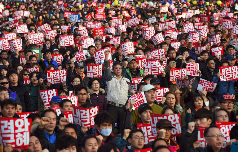 Tens of thousands of protesters hold up signs calling for the resignation of South Korean President Park Geun Hye during an anti-government rally following presidential scandal in central Seoul