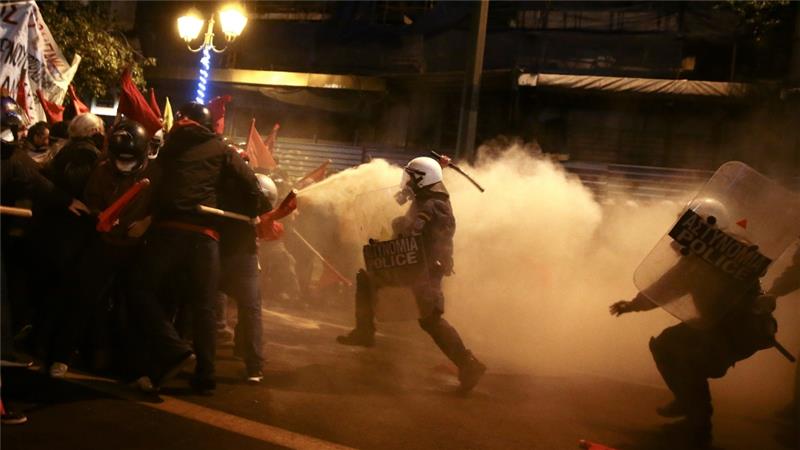 Protesters clash with riot police during a demonstration against the visit of President Obama