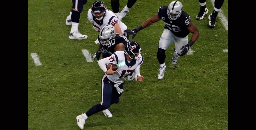 A green light hits the jersey of Houston Texans quarterback Brock Osweiler as he runs during the second half of an NFL football game against the Oakland Raiders Monday Nov. 21 2016 in Mexico City