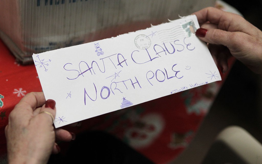 U.S. Postal Service employee Carrie Montserrat holds a letter addressed to Santa Claus at the North Pole as she and her colleagues sort letters written to Santa Claus as part of Operation Santa at a post office in Santa Ana Calif. Wednesday Dec. 15 20