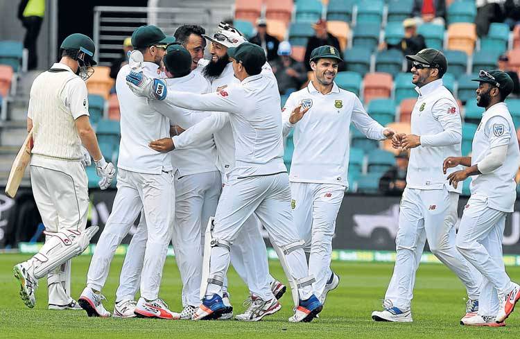 SIX OF THE BEST Proteas paceman Kyle Abbott centre celebrates his wicket of Australia’s batsman Adam Voges with teammates on the fourth day's play of the second Test match between the sides in Hobart yesterday. Abbott finished with six wickets for