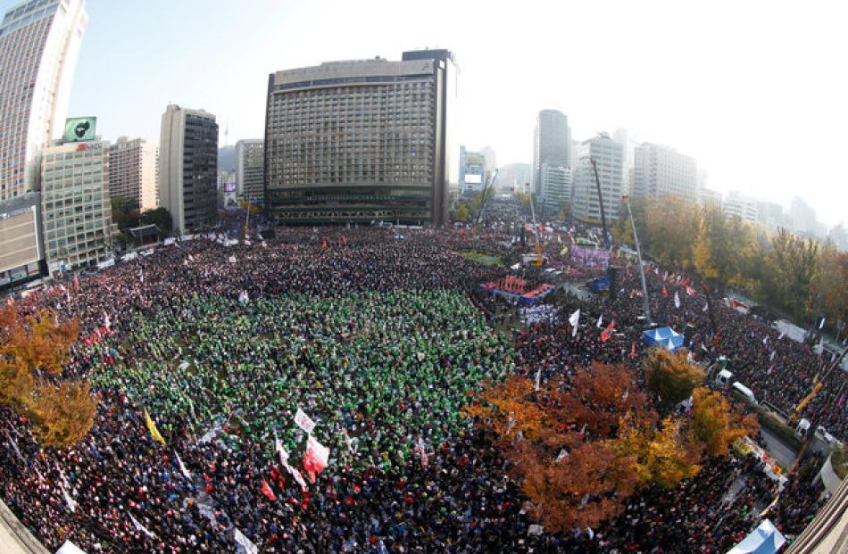 Hundreds of thousands shout slogans as they carry placards reading'Park Geun-hye Out, during