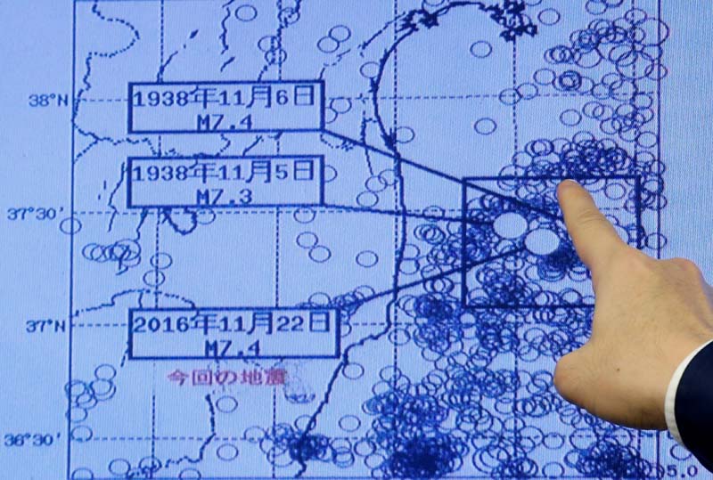 Japan Meteorological Agency's earthquake and volcano observations division director Koji Nakamura points at a map showing earthquake information during a news conference in Tokyo