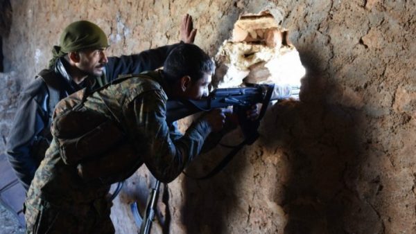 A fighter from the Syrian pro-government forces mans a rifle inside a damaged house in the recently recaptured village of Joubah during an offensive towards the area of Al Bab in Aleppo province