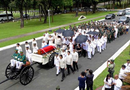 The flag-draped coffin of former Philippine dictator Ferdinand Marcos is seen atop a military hearse in Manila Nov. 18