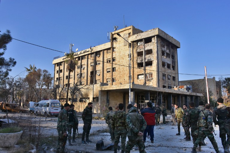 Syrian pro-government forces gather in front of a water pumping station in the Suleiman al Halabi neighborhood of Aleppo