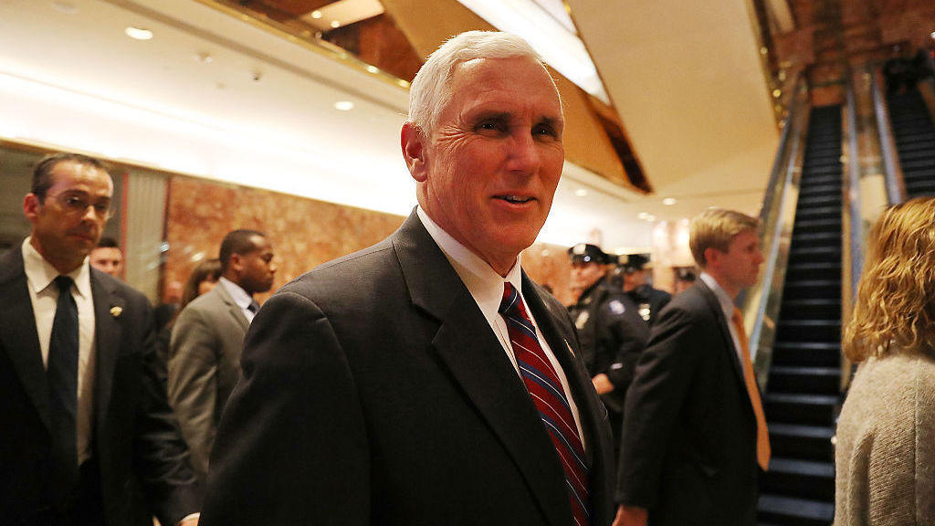 Vice President-elect Mike Pence who is now overseeing President-elect Donald Trump's transition walks by reporters while exiting Trump Tower on Tuesday