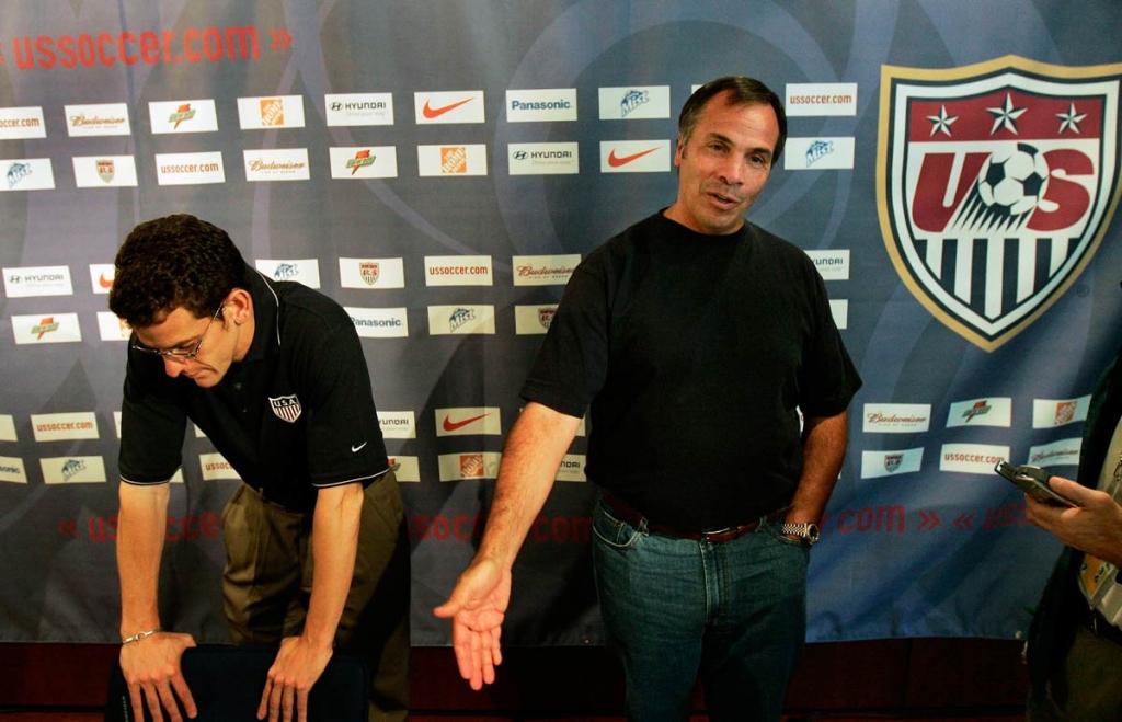 United States team manager Bruce Arena right speaks to journalists about being eliminated from the 2006 soccer World Cup at a news conference in Hamburg Germany as press officer Michael Kammarman listens at left. (AP