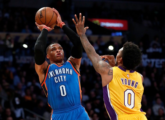 Oklahoma City Thunder guard Russell Westbrook left shoots over Los Angeles Lakers guard Nick Young during the first half of their NBA basketball game Tuesday Nov. 22 in Los Angeles