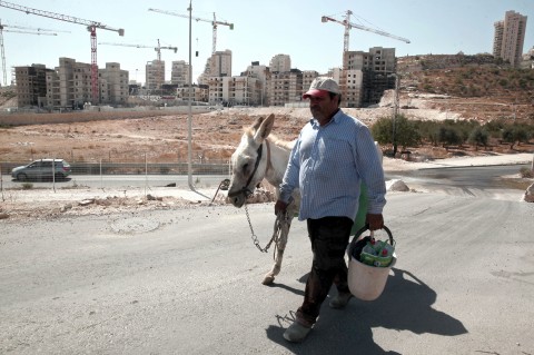 A Palestinian man walks near a housing construction site of in East Jerusalem