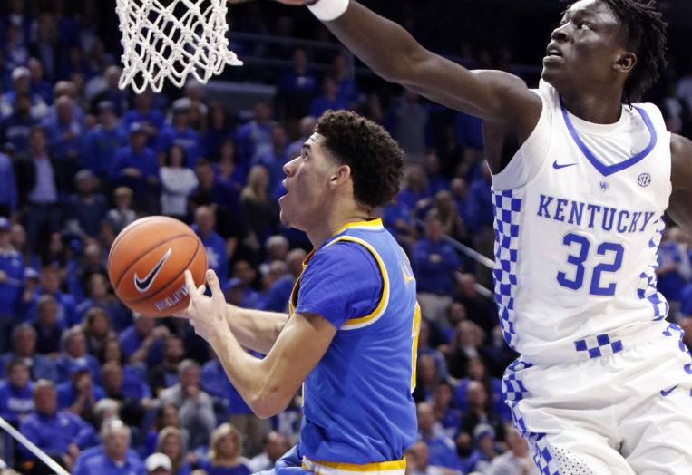 UCLA's Lonzo Ball left shoots while defended by Kentucky's Wenyen Gabriel during the first half of an NCAA college basketball game Saturday Dec. 3 2016 in Lexington Ky. UCLA upset No. 1 Kentucky 97-92