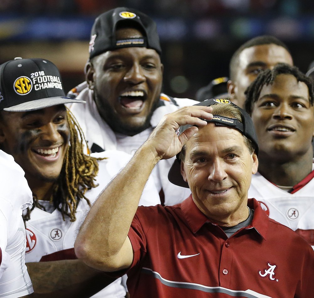 Alabama head coach Nick Saban and team members celebrate after the Southeastern Conference championship game against Florida on Saturday in Atlanta. Alabama won 54-16 and will be the No. 1 seed in this year's College Football playoffs