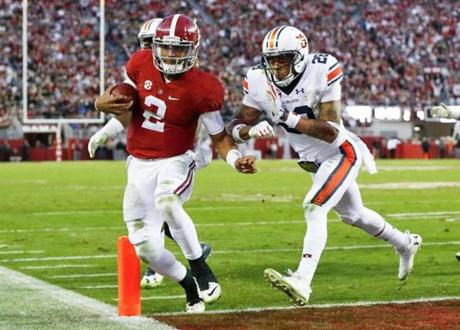 Auburn defensive back Tray Matthews pushes Alabama quarterback Jalen Hurts as he runs in for a touchdown against during the first half of the Iron Bowl NCAA college football game Saturday Nov. 26 2016 in Tuscaloosa Ala