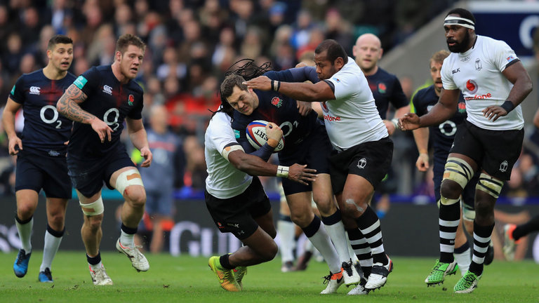 Alex Goode of England is tackled by Albert Vulivuli and Sunia Koto of Fiji