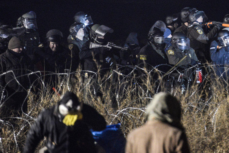 Police confront protesters with a rubber bullet gun near Cannon Ball N.D. on Sunday during a protest against plans to pass the Dakota Access Pipeline near the Standing Rock Indian Reservation