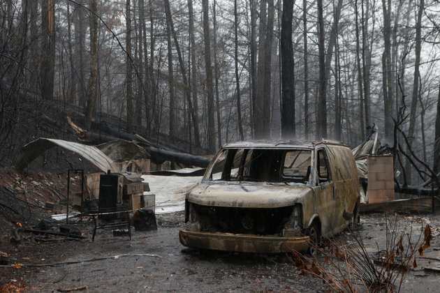 Brian Blanco via Getty Images
The remains of a van and home smolder in the wake of a wildfire Wednesday in Gatlinburg Tennessee