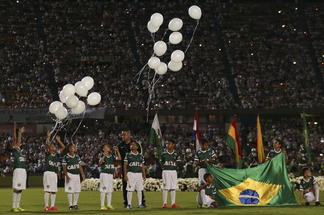 Children release balloons during a tribute to members of Brazil's Chapecoense soccer team who died in a plane crash