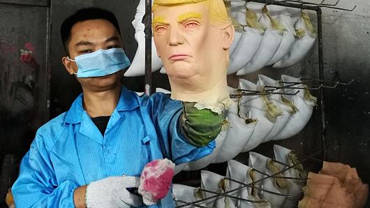 An employee shows a mask of American president-elect Donald Trump at a latex crafts factory