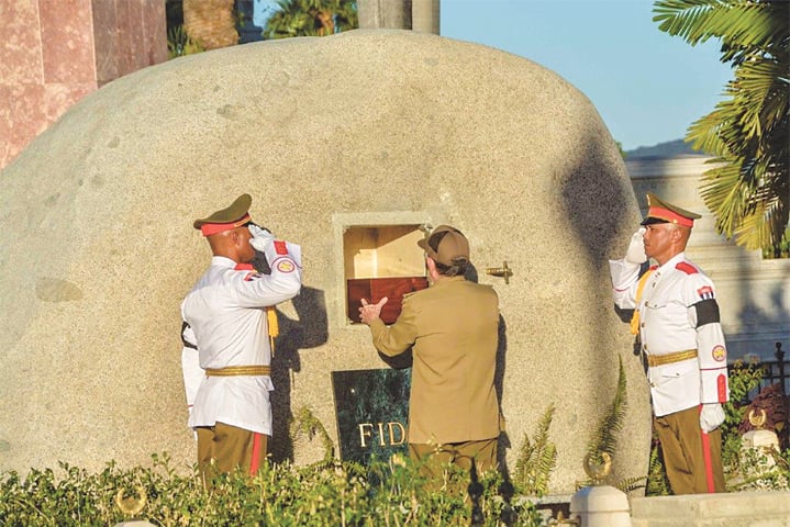 Cuban President Raul Castro places the urn with the ashes of his brother Fidel Castro in his tomb at the Santa Ifigenia cemetery on Sunday.—AFP