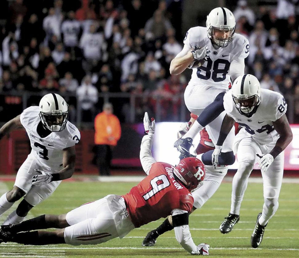 Mike Gesicki hurdles Rutgers’ Saquon Hampton while following behind blockers De Andre Thompkins and Juwan Johnson Saturday evening in Piscataway NJ