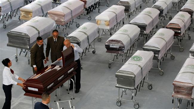 Funeral workers prepare a coffin with the remains of a victim of a plane crash in Medellin Colombia