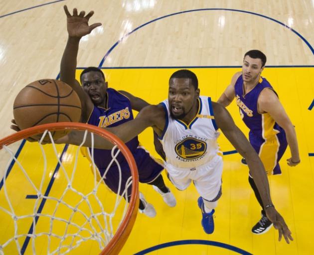 Golden State Warriors forward Kevin Durant takes the ball to the hoop against the Lakers