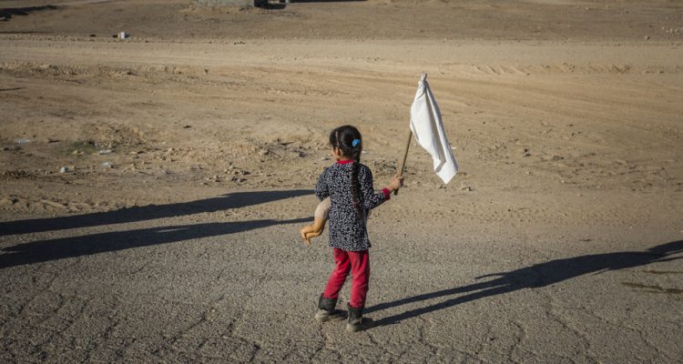 A young girl carrying a teddy bear and waving a white flag heads towards an army outpost in the Samah neighbourhood on the eastern outskirts of Mosul away from the heavy fighting engulfing the city