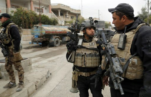 Soldiers from the Iraqi special forces secure a street in the Al Bakr neighbourhood of Mosul during an operation against Islamic State group jihadists