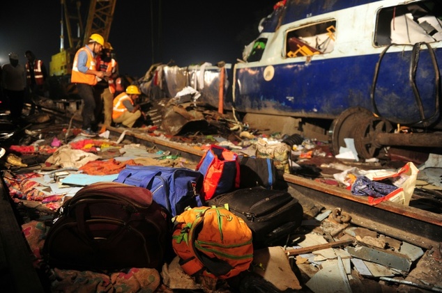 Rescue workers search for survivors in the wreckage of a derailed train near Pukhrayan in Kanpur district northern India