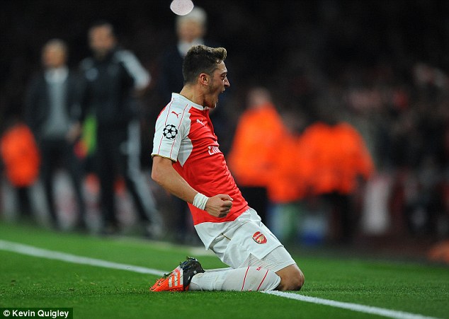 Mesut Ozil celebrates with a knee slide after his goal helped Arsenal beat Bayern last season