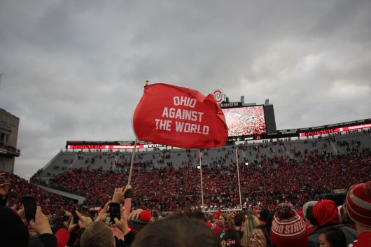 Fans wave a flag on the field after the Buckeyes game against Michigan on Nov. 26 at Ohio Stadium. The Buckeyes won 30-27. Credit Mason Swires | Assistant