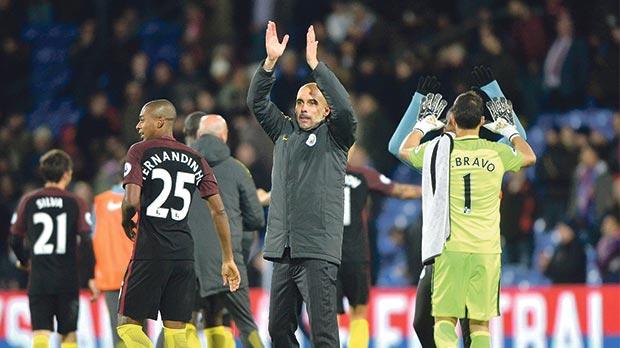 Manager Pep Guardiola applauds the fans after Man. City’s win over Crystal Palace