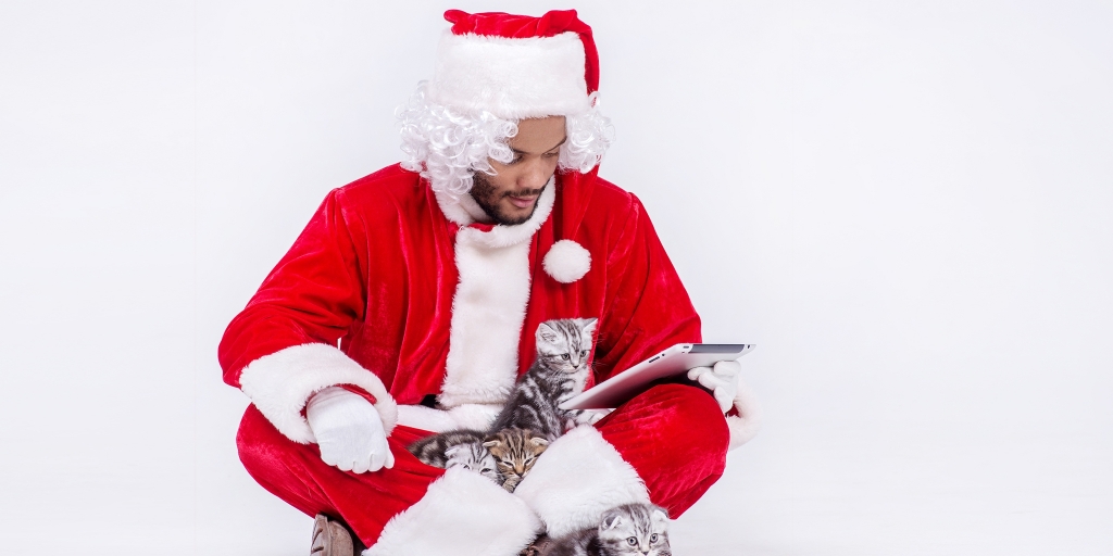 Black Santa reading tablet with kitten